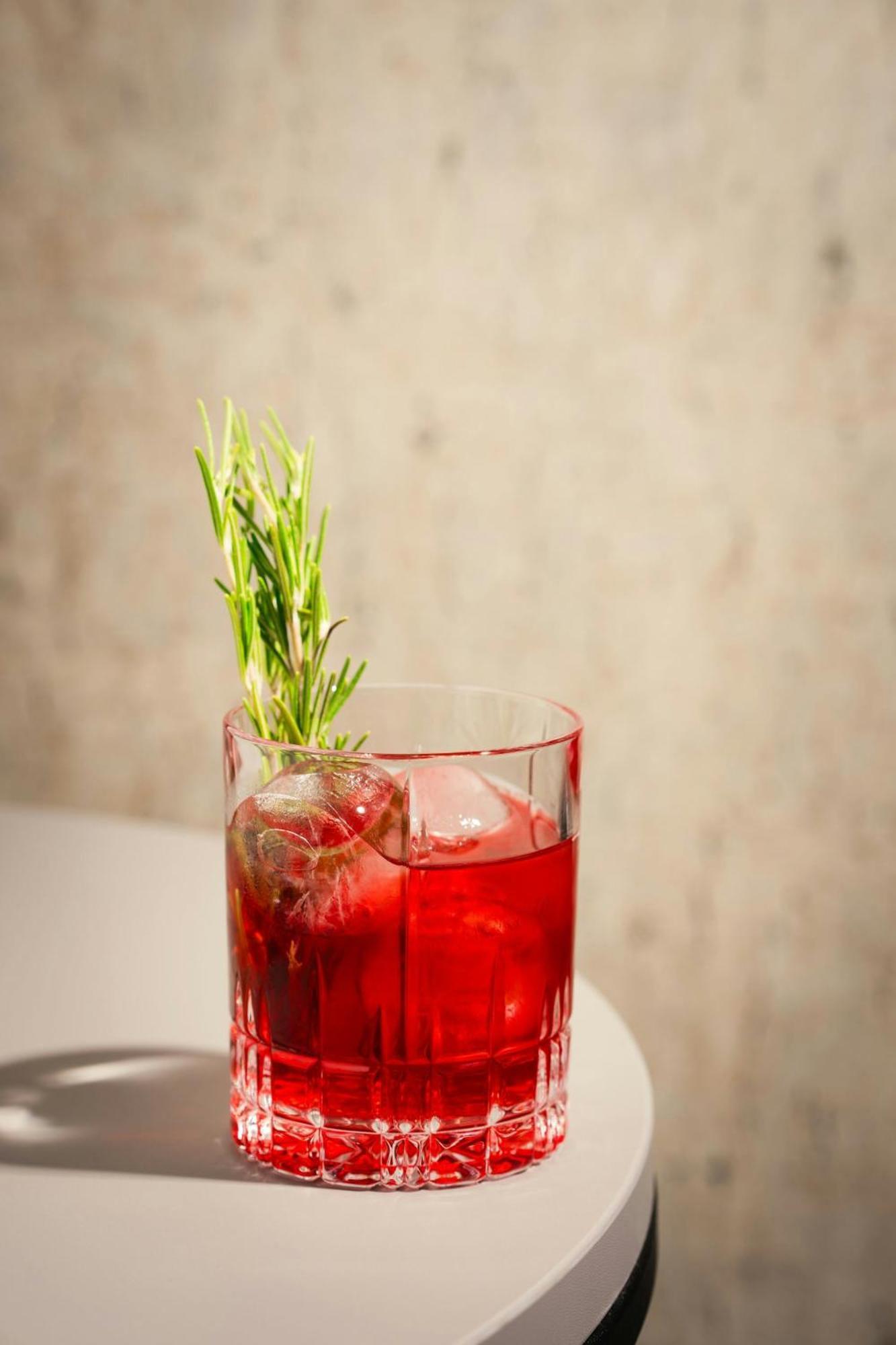 โรงแรมเรอเนซองส์ ฮัมบวร์ค ฮัมบูร์ก ภายนอก รูปภาพ A Negroni garnished with a sprig of rosemary